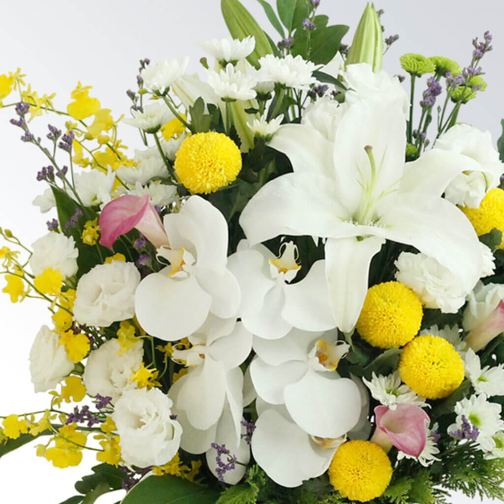 真っ白なユリをメインに色花を使った豪華なフラワーアレンジメント